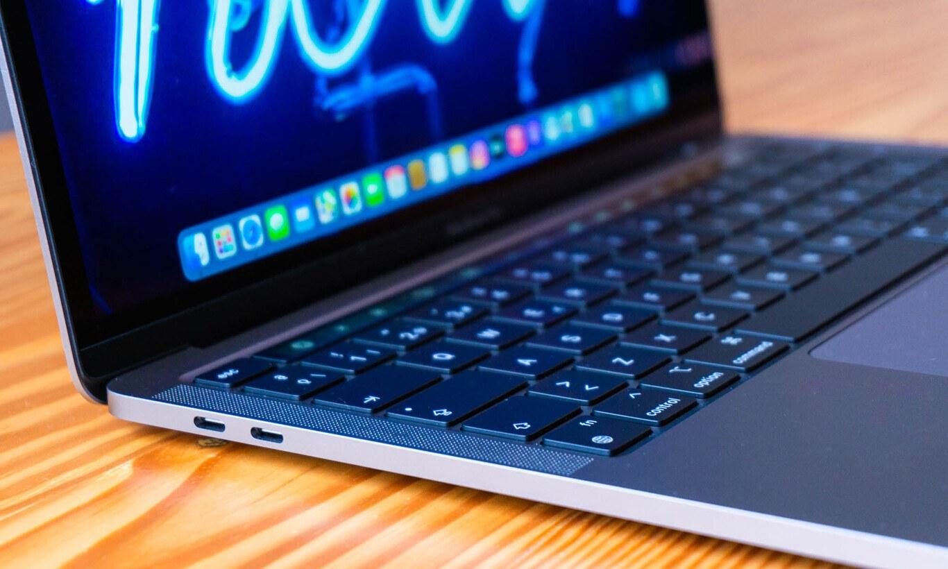 An Apple MacBook Pro laptop, half open, showing its keyboard and screen