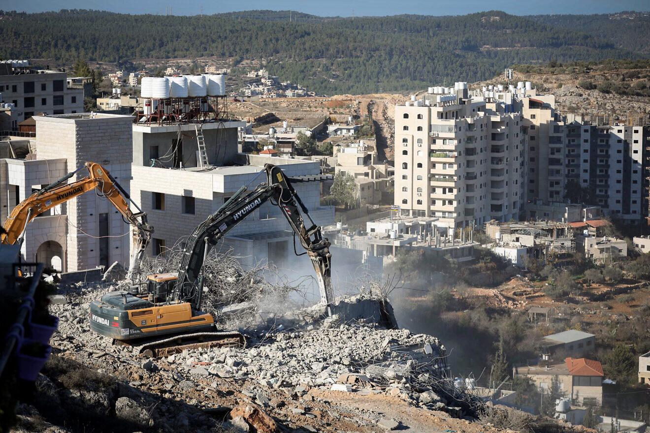 Excavators working among apartment blocks on a West Bank hillside